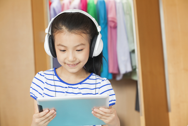 Chinese girl listening to headphones with digital tablet