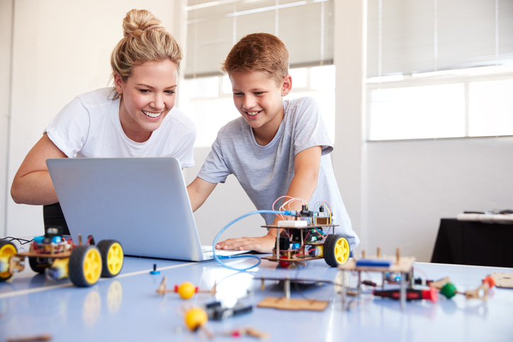 Male Student With Teacher Building Robot Vehicle In After School Computer Coding Class